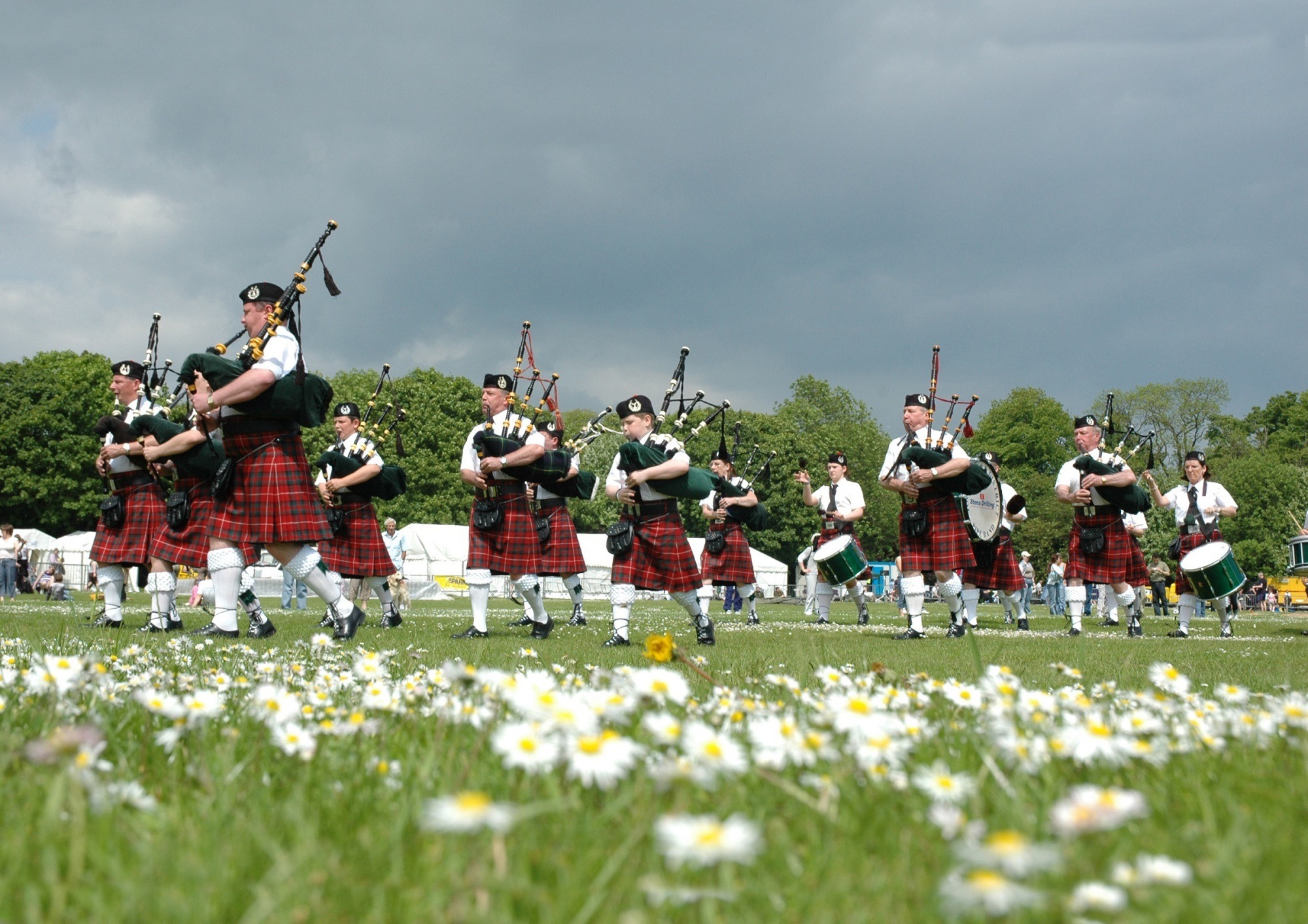 Group of Scottish men playing bagpipes in traditional garb