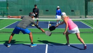 Group of seniors playing an intense match of pickleball on a sunny outdoor court