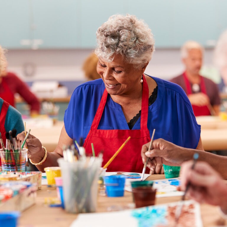 Retired senior woman attending art class in community centre