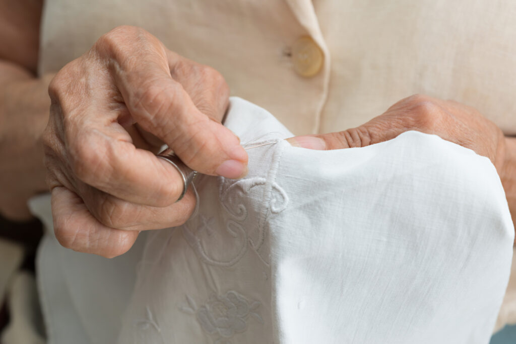 Senior woman stitching embroidery by hand on a kerchief