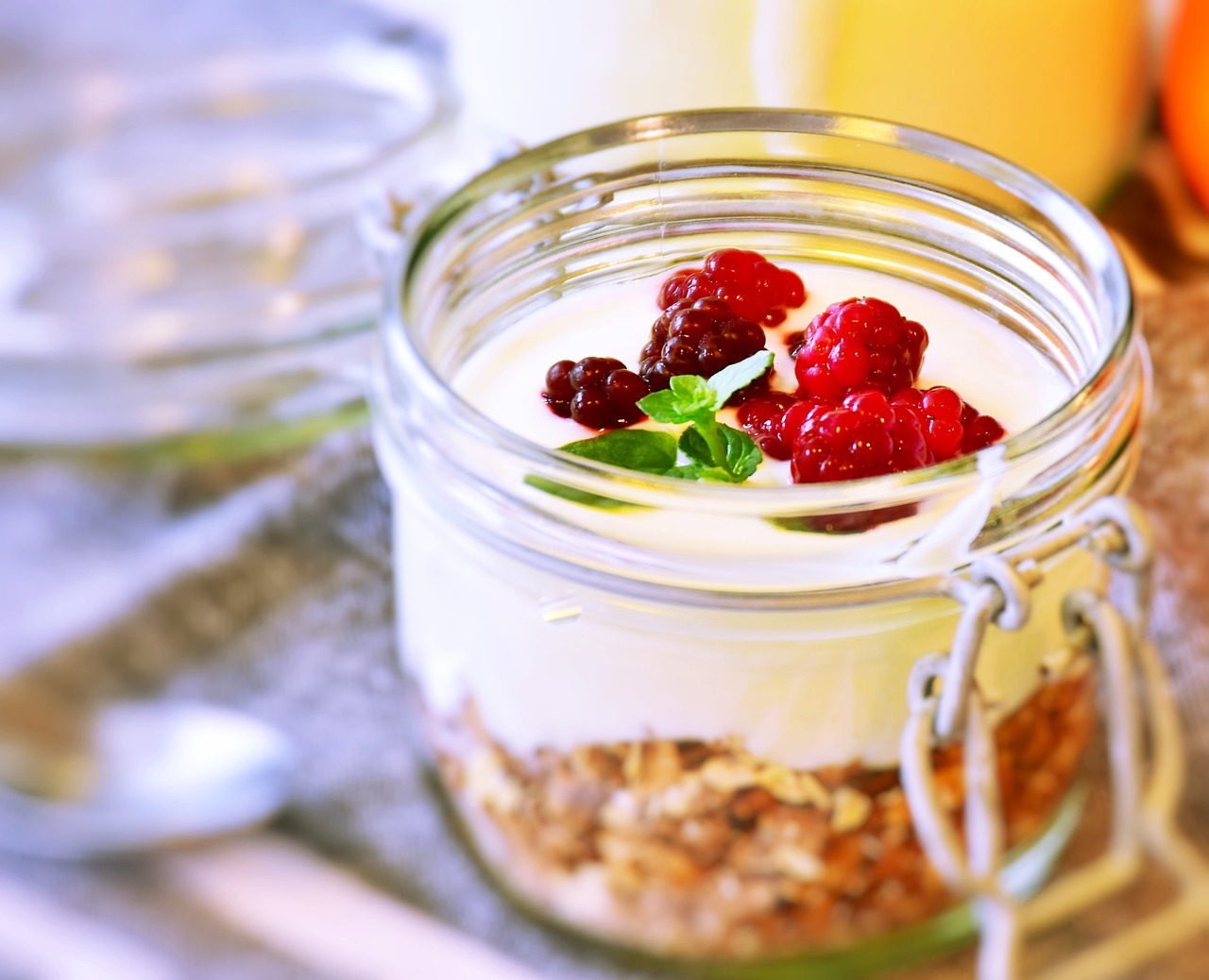 Mason jar with breakfast parfait of greek yoghurt, cereals, and berries