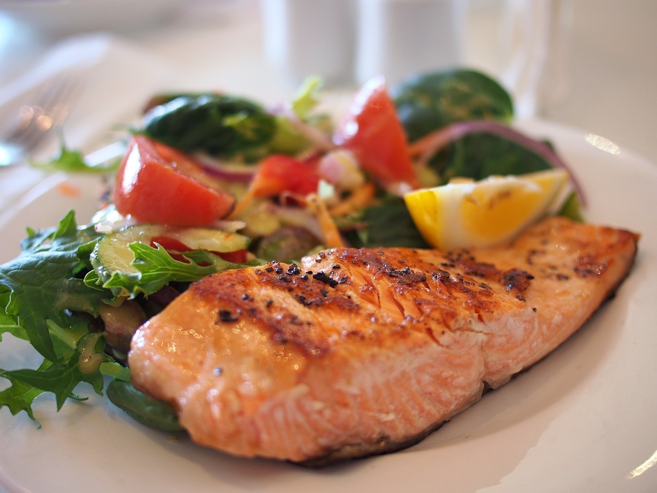 Plate of grilled salmon with a side of greens