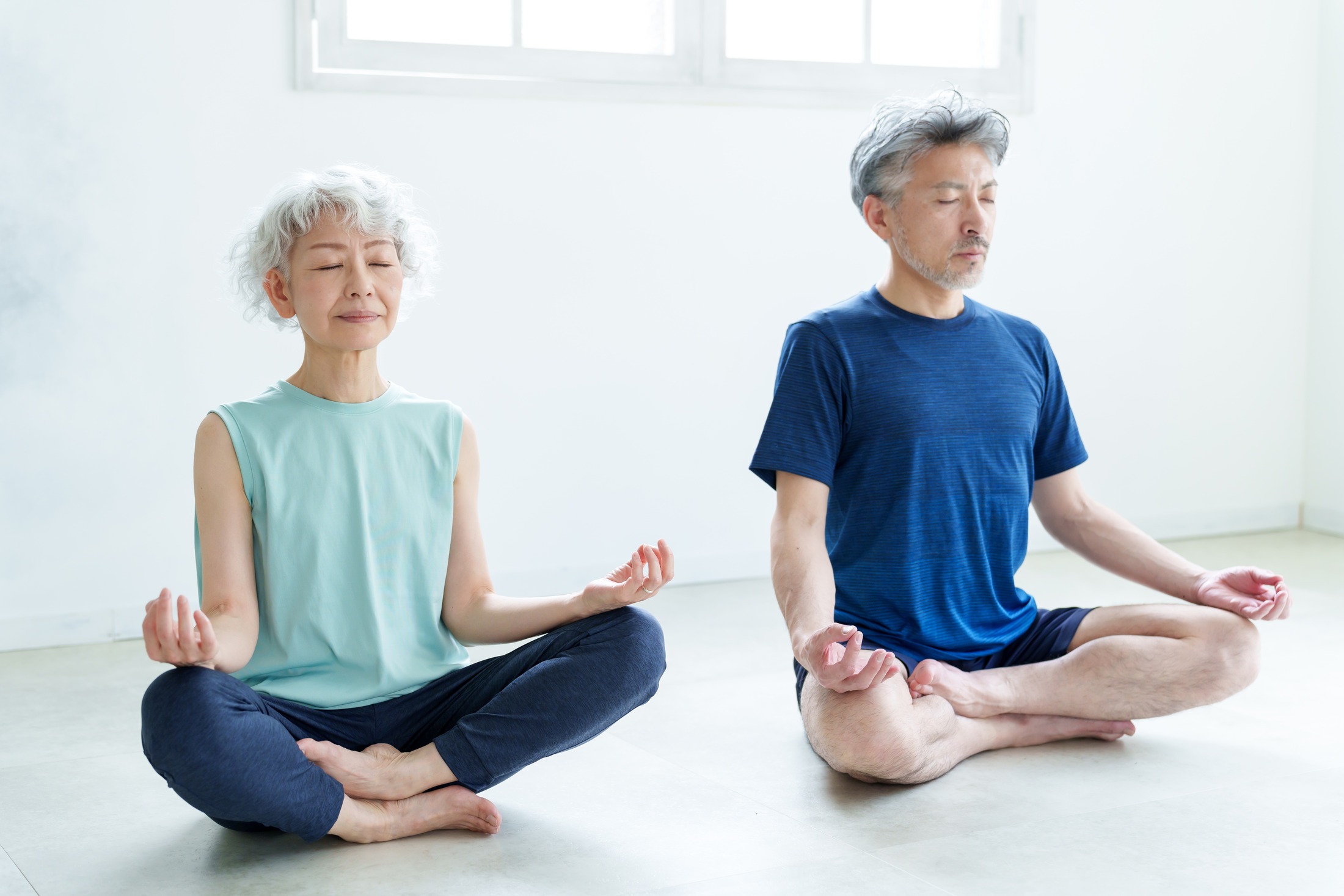 Senior Asian couple peacefully meditating
