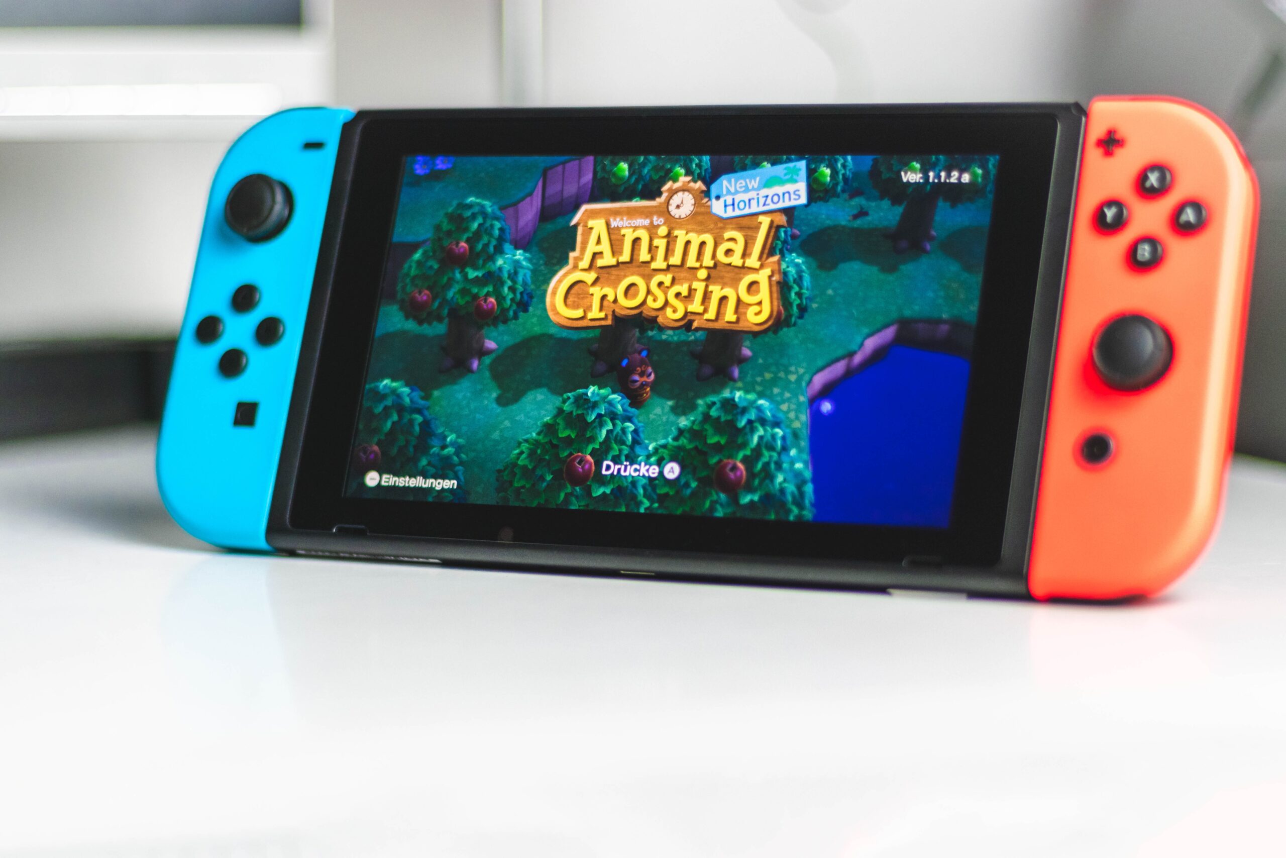 Close up of a Nintendo Switch displaying the menu screen for Animal Crossing