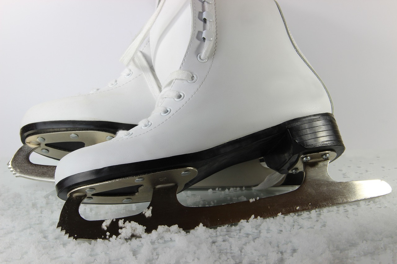 Close up of white ice skates on the ice