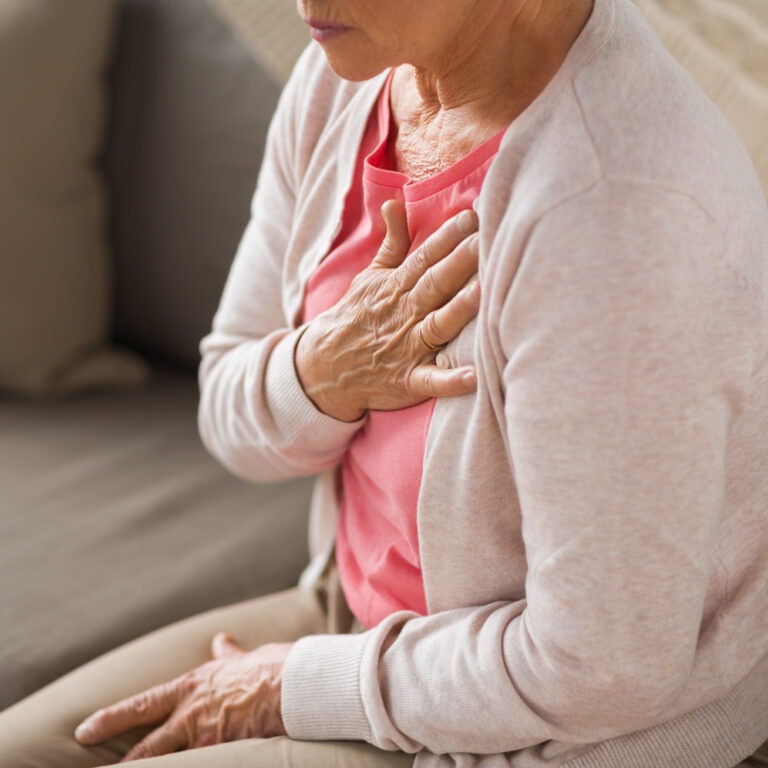 Senior woman with her hands on her chest in pain