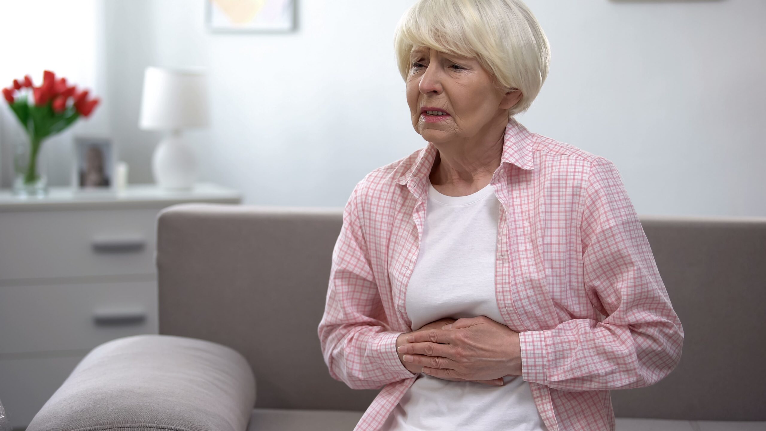 Close-up of an elderly persons’ hand on their upset stomach