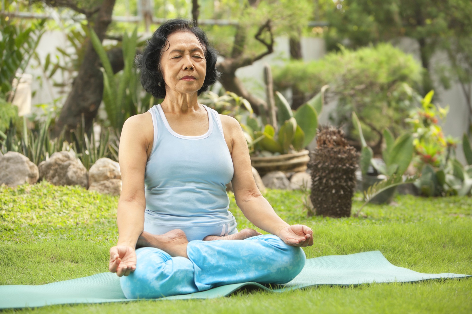 Asian senior woman meditating for yoga outside