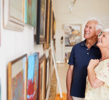 Senior couple looking at paintings in art gallery enjoying Coquitlam arts and culture