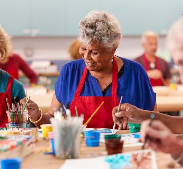 Retired senior woman attending art class in community centre