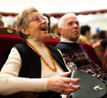 Elderly couple enjoying a performance at the theatre