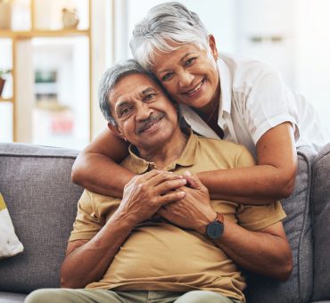 Happy senior couple together on a sofa in their living room