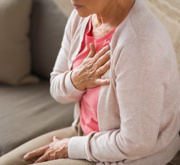 Senior woman with her hands on her chest in pain