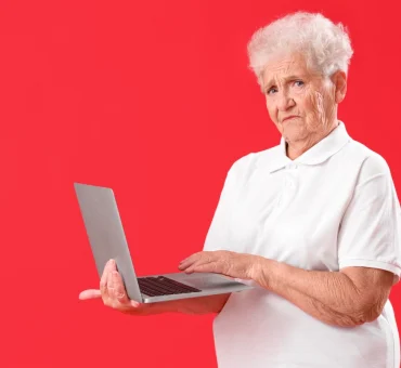Senior Woman Using Laptop on Red background