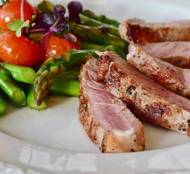 Dinner plate with roasted pork, asparagus and cherry tomatoes