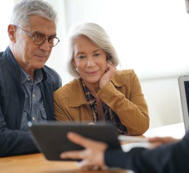 senior couple being shown senior retirement community options on tablet