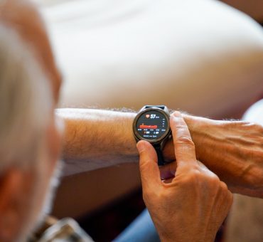Elderly man checking his cardiogram ECG using a smartwatch wearable health technology